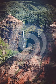 Contrasty image where a natural cascade falls over brown dry ground