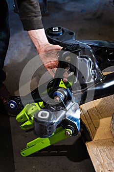 Control arms with polyurethane bushings installing process on drift car subframe. Installing drift suspension arms improves