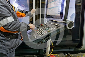The control panel of a CNC machine, a worker writes a program for processing parts on a machine by cutting