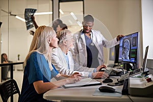 In Control Room Doctors and Radiologists Discuss Diagnosis while Looking at Computer Tomography X-ray image