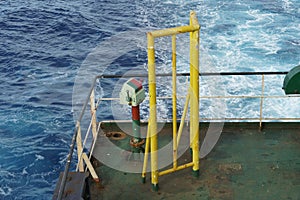 Control station of ship afterdeck mooring winch behind yellow construction.