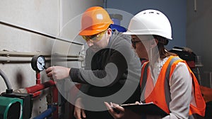 The controller and the engineer in the boiler room to inspect the condition of pipes, condition of equipment and record