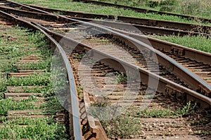 Converging, diverging and interwoven rusty rail in the light of the sun in summer