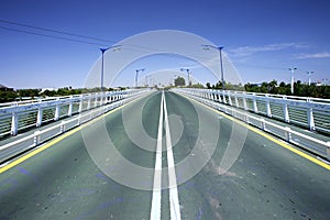 Converging lines of road on bridge photo