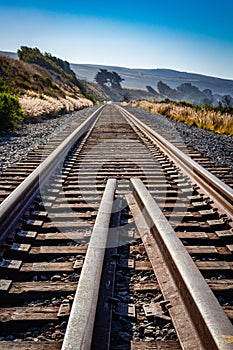 Converging railroad tracks along the ocean coastline