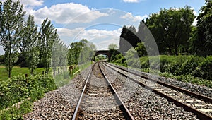 Converging Railway tracks passing under a bridge