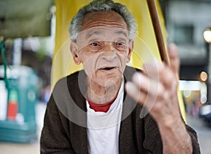 Conversation, city and senior man talking in a neighborhood outdoor with chat and communication. Urban, sitting and