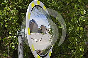 A convex traffic mirror where you can see parts of the campus
