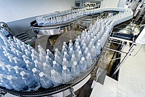 Conveyor belt with bottles of drinking water at a modern beverage plant.