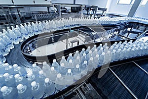 Conveyor belt with bottles of drinking water at a modern beverage plant.