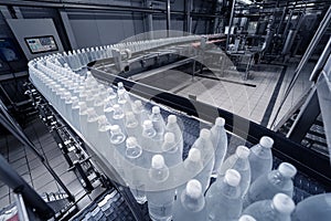 Conveyor belt with bottles of drinking water at a modern beverage plant.