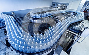 Conveyor belt with bottles of drinking water at a modern beverage plant.