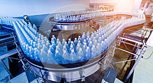 Conveyor belt with bottles of drinking water at a modern beverage plant.