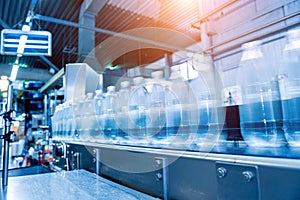 Conveyor belt with bottles of drinking water at a modern beverage plant.