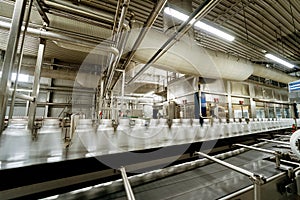 Conveyor belt with bottles of drinking water at a modern beverage plant.