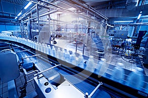 Conveyor belt with bottles of drinking water at a modern beverage plant.