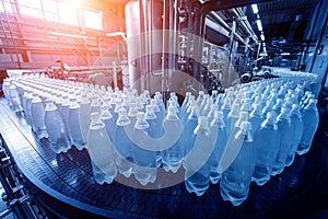 Conveyor belt with bottles of drinking water at a modern beverage plant.