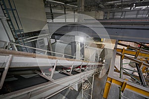 The conveyor belt of ingredients to the mixer. Workers in the workshop of the House-building plant. Industrial interior