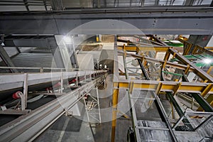 The conveyor belt of ingredients to the mixer. Workers in the workshop of the House-building plant. Industrial interior