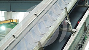 The conveyor belt of ingredients to the mixer. Workers in the workshop of the house-building plant. Industrial interior