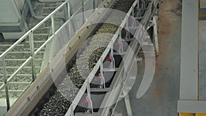 The conveyor belt of ingredients to the mixer. Workers in the workshop of the House-building plant. Industrial interior