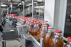 Conveyor belt or line in beverage factory or plant interior inside with modern industrial machine equipment. Bottles