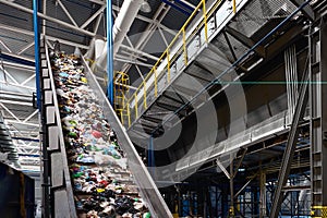 Conveyor belt transports garbage inside drum filter or rotating cylindrical sieve with trommel or sorting pieces of garbage into