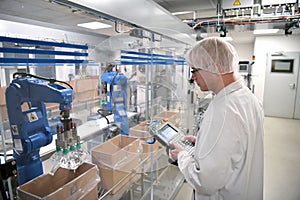 Conveyor belt worker operates a robot that transports insulin ba