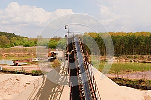 Conveyor belts and sand heaps. Construction industry. Sand quarry, heavy duty machinery. Horizontal photo
