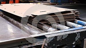 Conveyor line for the production of boxes. Machine carves cardboard boxes from sheets of cardboard. Enterprise for the production