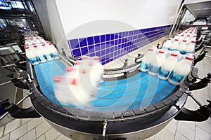 Conveyor with wrapped milk bottles at factory