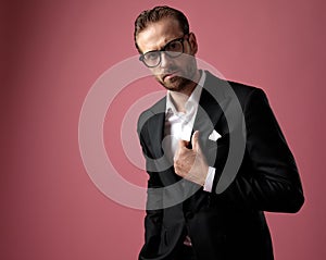 Convinced groom adjusting his jacket