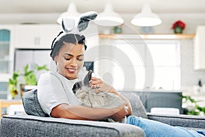 Convinced my husband the rabbit was for the kids. Shot of a young woman playing a rabbit at home.