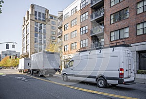 Convoy of different trucks with box trailers and long compact mini van