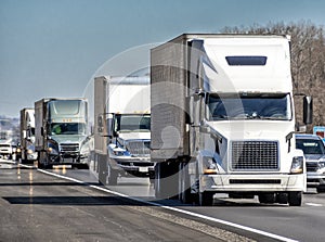 Convoy of Eighteen Wheeler Trucks on Interstate Highway