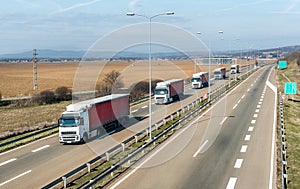 Convoy of transportation trucks in line on a country highway