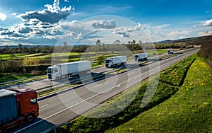 Convoy of white transportation trucks