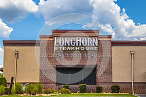 Back of LongHorn Steakhouse with blue sky and clouds