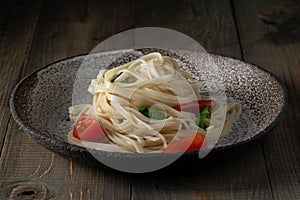 Coocked egg noodles with tomatoes and basil photo
