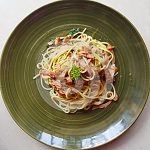 Cook Aglio olio pasta on a green plate