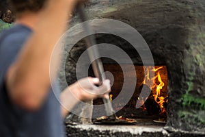 Cook baking pizza in a traditional oven