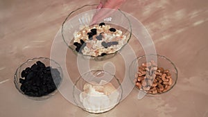 The cook boils the cottage cheese, beats, adds raisins and nuts, stirring the curd mass. Knead the curd dough in a white