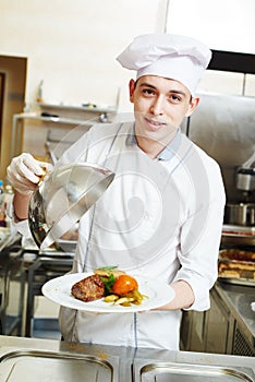 Cook chef with food in kitchen