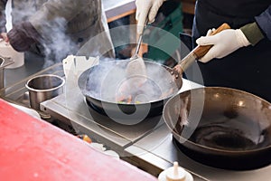 Cook or chef frying in a commercial kitchen