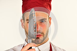 Cook or chef with knife near eye on white background