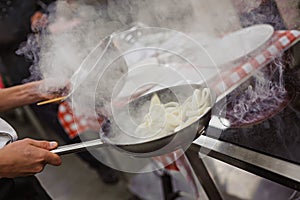 Cook cookes the squid on frying pan