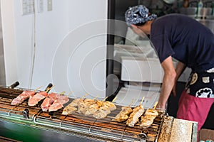 A Cook Is Cooking Tuna Sticks On A Fish Market