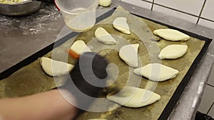 Cook in the culinary shop makes dough rolls pies and pretzels