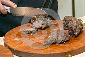 Cook cuts roasted beef meat. The concept of cooking