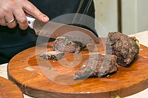 Cook cuts roasted beef meat. The concept of cooking